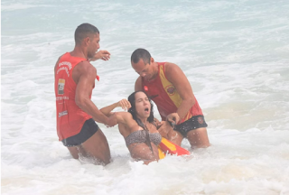 Mulher Melão se afoga na praia da Barra e é socorrida por salva-vidas.